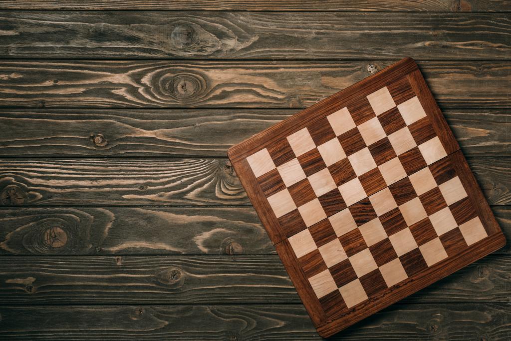Вид сверху шахматной доски на деревянной поверхности
 - Фото, изображение