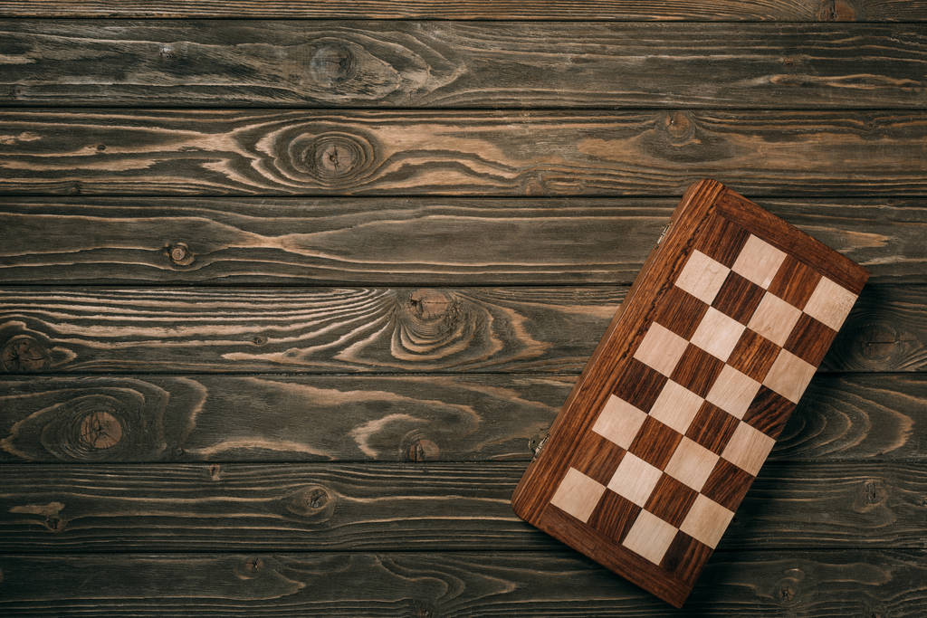 Horní pohled na šachovnici na texturovaném dřevěném pozadí - Fotografie, Obrázek