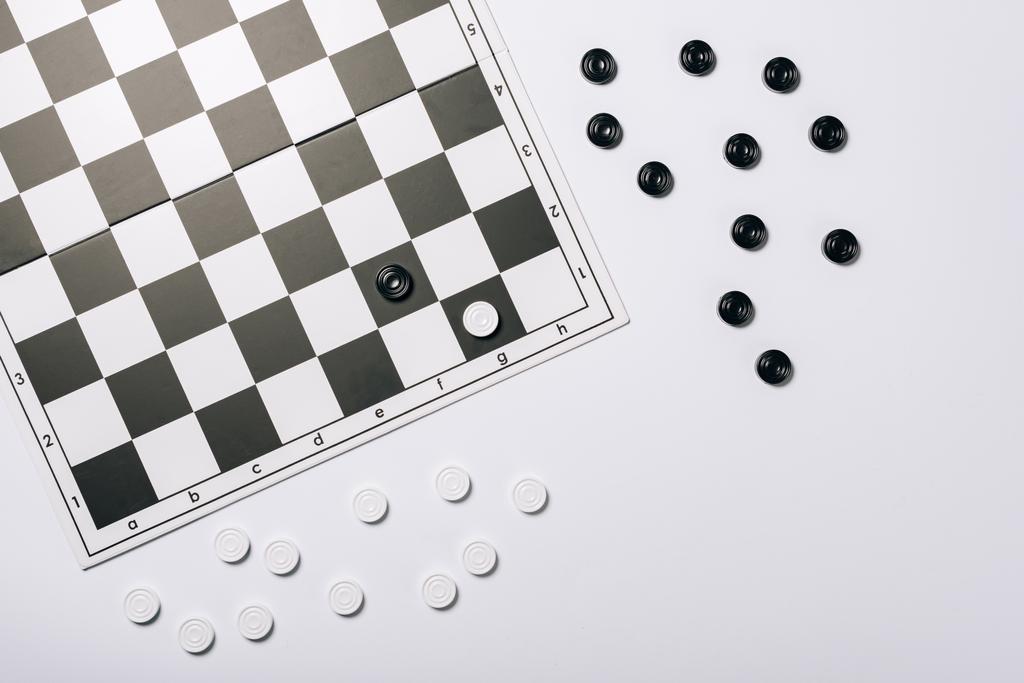 白に隔離された黒と白のチェッカー付きチェス盤のトップビュー - 写真・画像