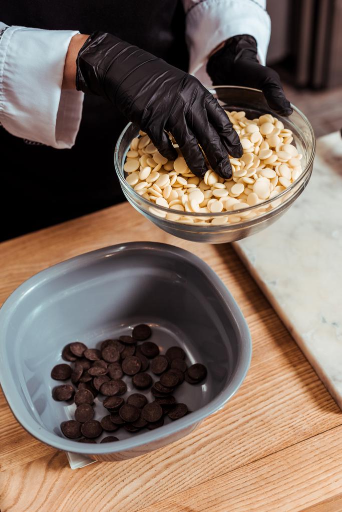 обрізаний вид шоколатьє додавання білих шоколадних чіпсів у миску
  - Фото, зображення