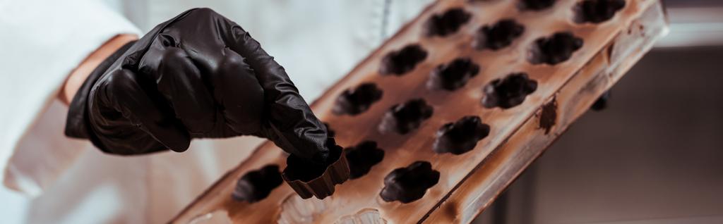 πανοραμικό shot σοκολατένιο κρατώντας καραμέλα σοκολάτα κοντά στο δίσκο πάγου  - Φωτογραφία, εικόνα