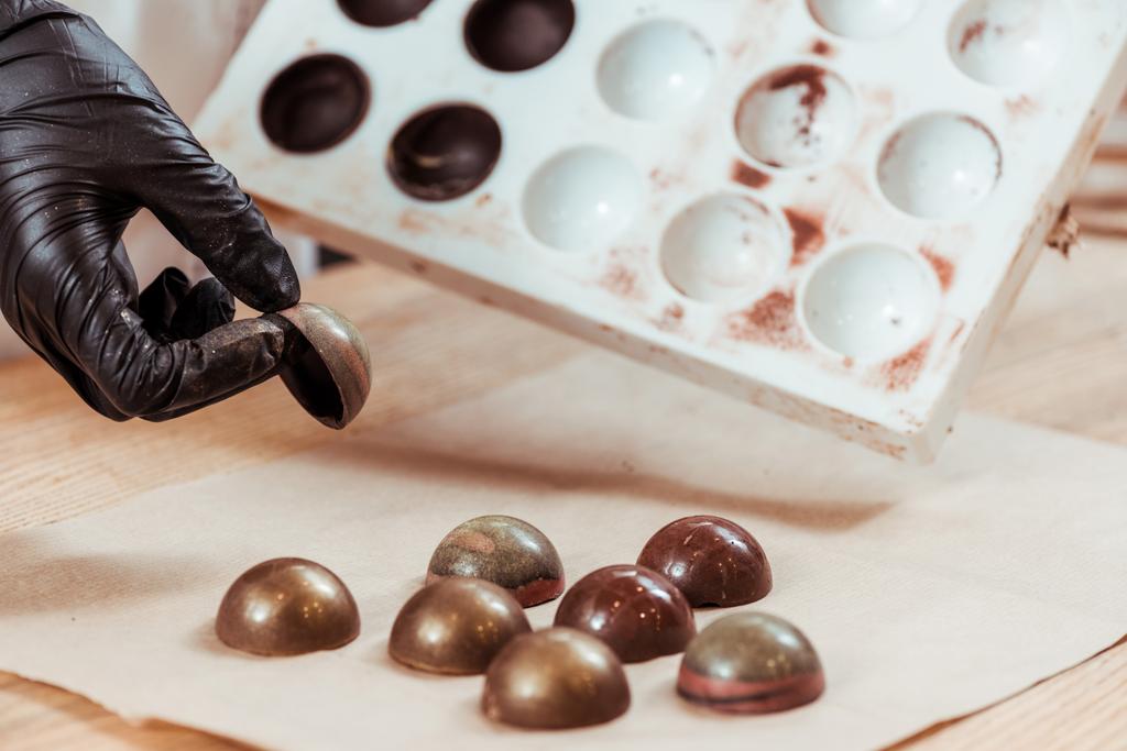 vue recadrée du chocolatier tenant des bonbons au chocolat au lait
  - Photo, image