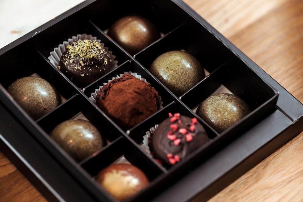 смачні шоколадні кульки з сушеною малиною та фісташковим порошком у коробці
  - Фото, зображення