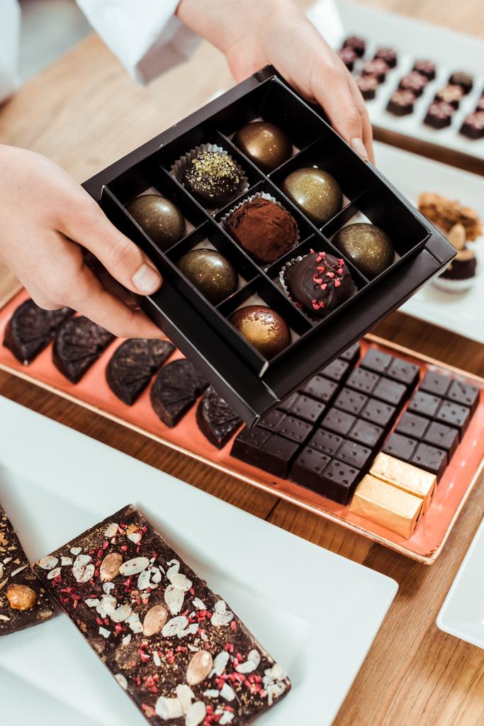 Çikolata kutusuyla nefis ve taze çikolatalı topların kırpılmış görüntüsü.  - Fotoğraf, Görsel