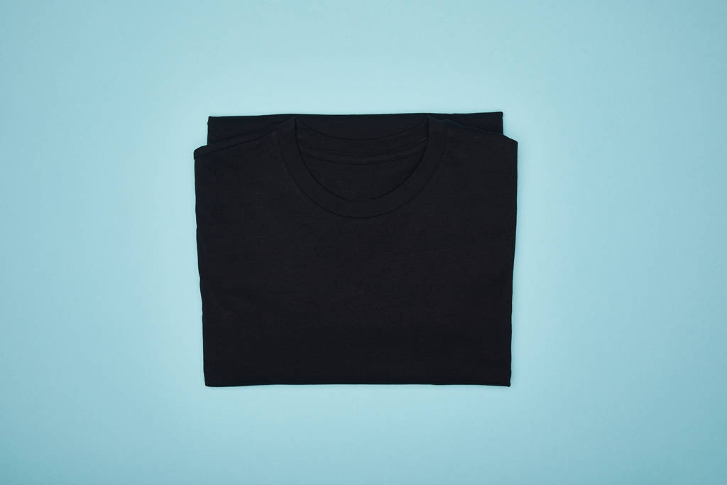 bovenaanzicht van blanco basic zwart t-shirt geïsoleerd op blauw - Foto, afbeelding