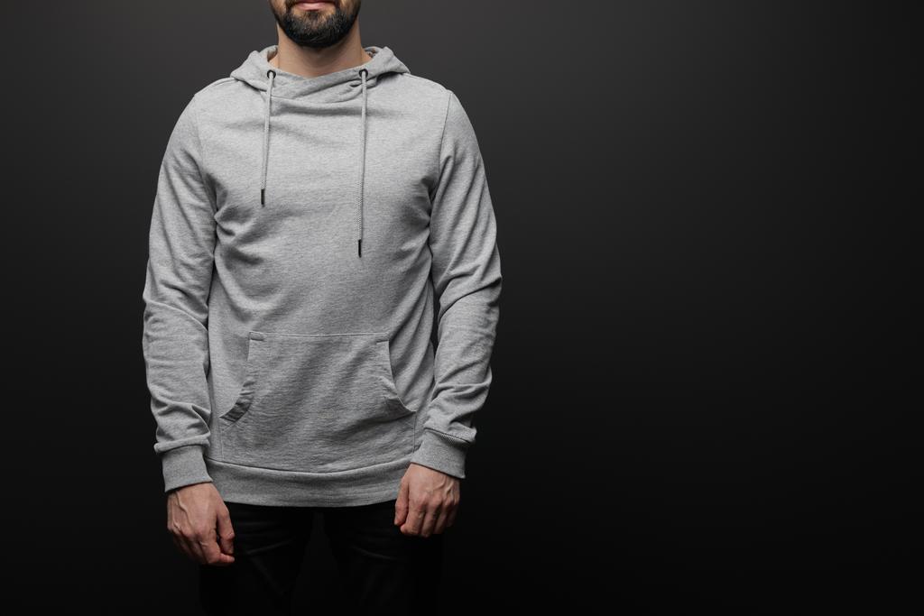 cropped view of bearded man in blank basic grey hoodie isolated on black background - Photo, Image