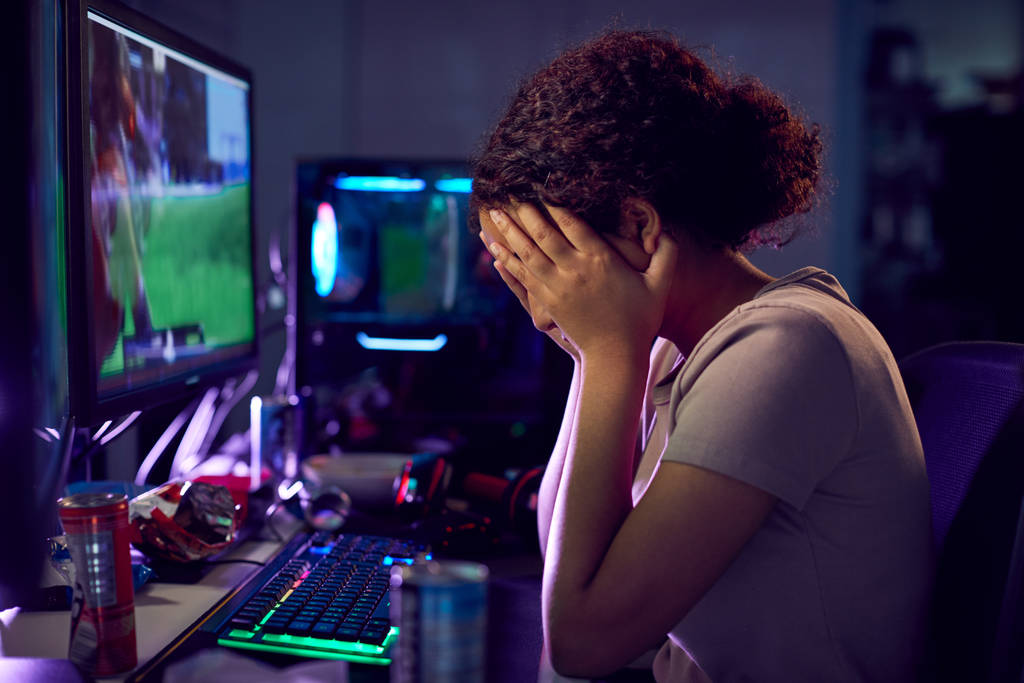 Chica adolescente estresada siendo acosada en línea mientras juega en casa
 - Foto, imagen