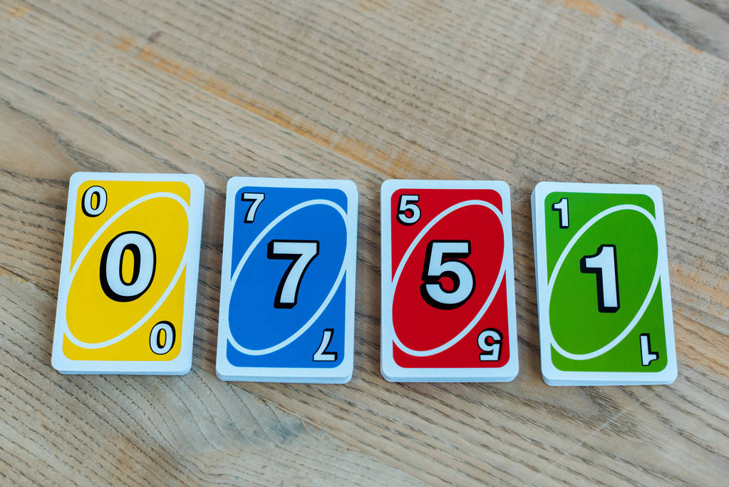 КИЕВ, УКРАИНА - 22 НОЯБРЯ 2019 г.: вид сверху на одно- игральные карты с номерами на деревянном столе
  - Фото, изображение
