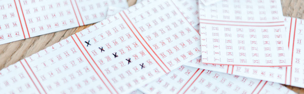 Panoramaaufnahme markierter Lottoscheine auf Holztisch - Foto, Bild