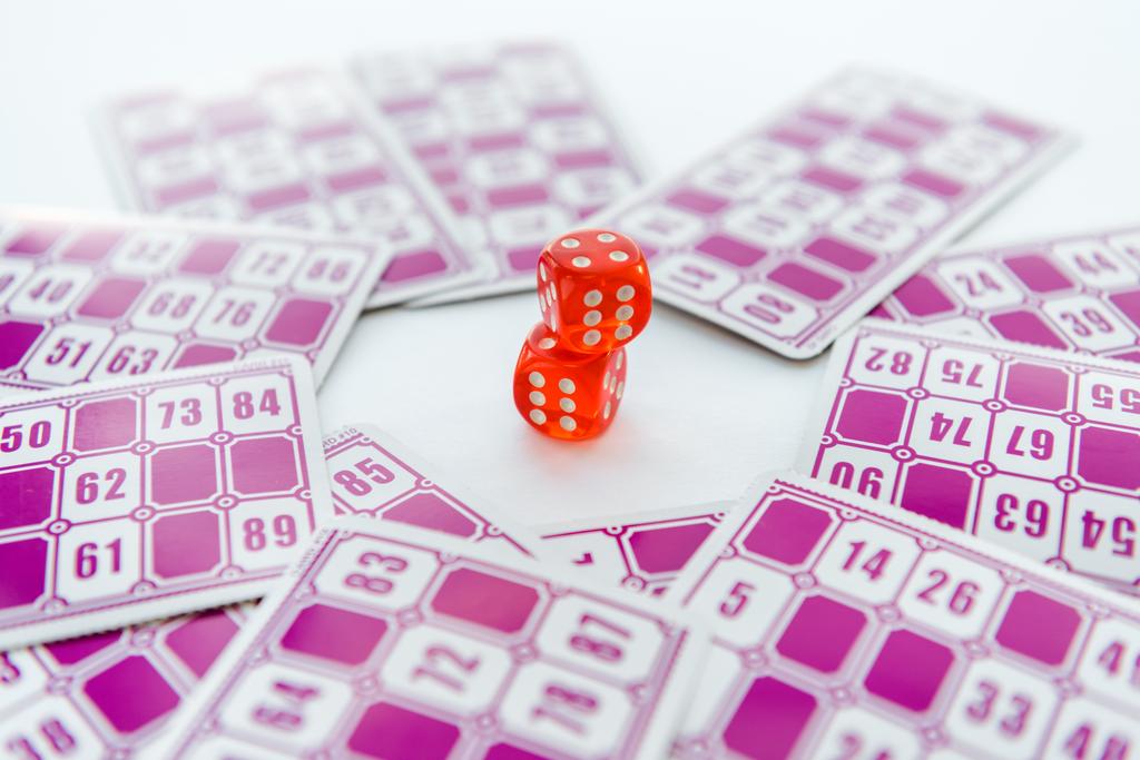 selective focus of red dice near lottery tickets isolated on white  - Photo, Image