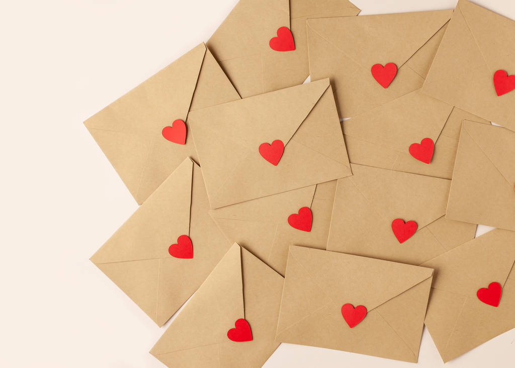 Valentin napi háttér. Piros szívű borítékok díszítik az asztalt. Felülnézet - Fotó, kép