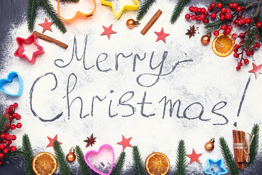 Tekst Vrolijk kerstfeest op meel met sparren takken, ornamenten en rode bessen - Foto, afbeelding