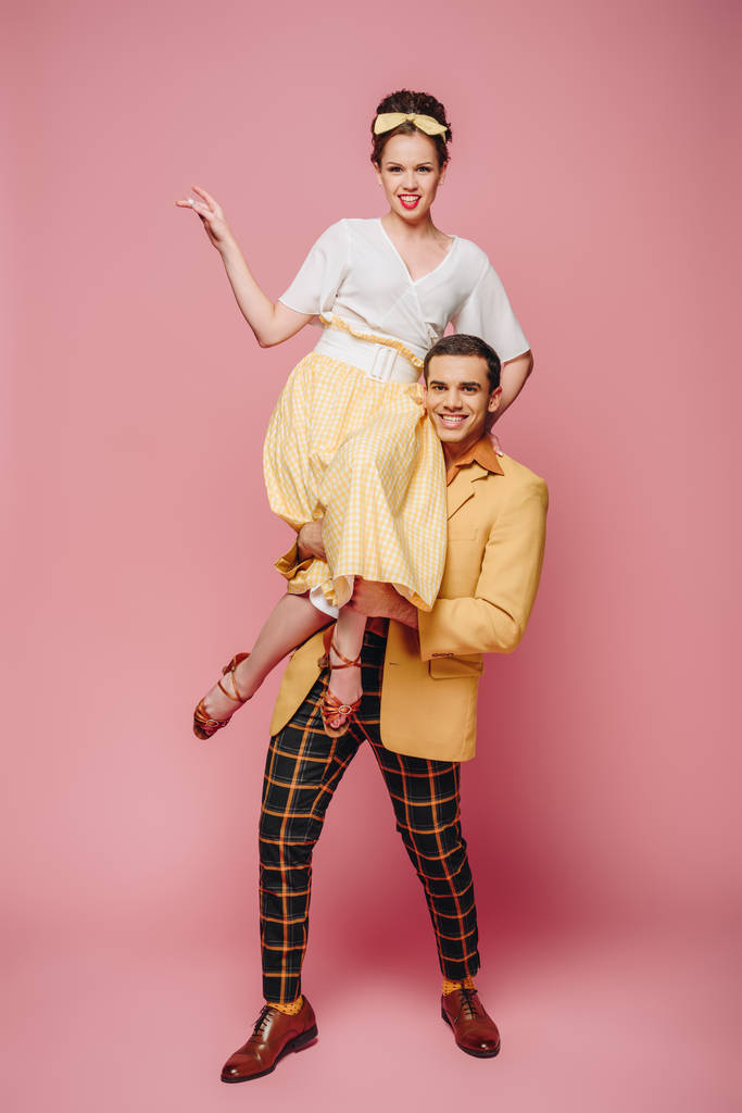 homem alegre segurando menina feliz enquanto dança boogie-woogie no fundo rosa
 - Foto, Imagem