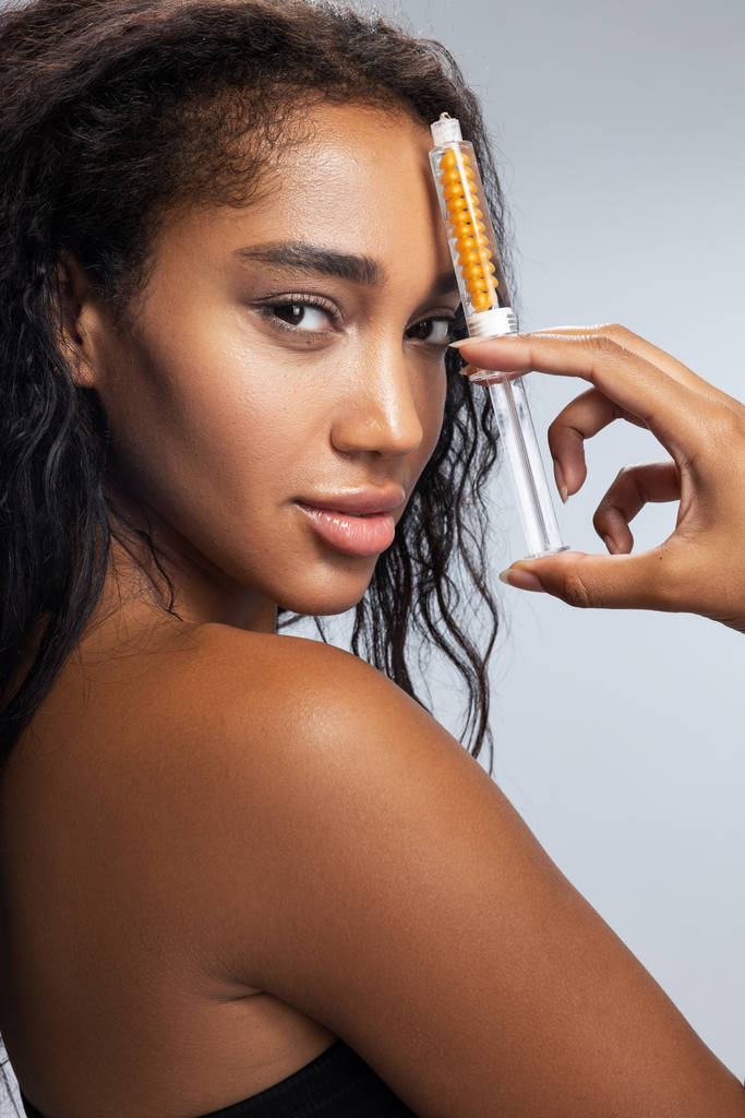 Очаровательная афро-американка с кудрявыми волосами, держащая шприц в руке
 - Фото, изображение
