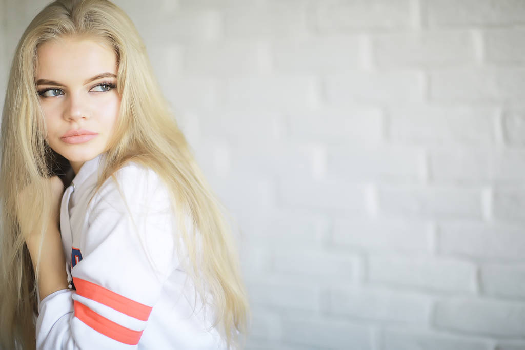 молодые взрослые блондинки длинные волосы дома, стильная модель позирует в студии
 - Фото, изображение