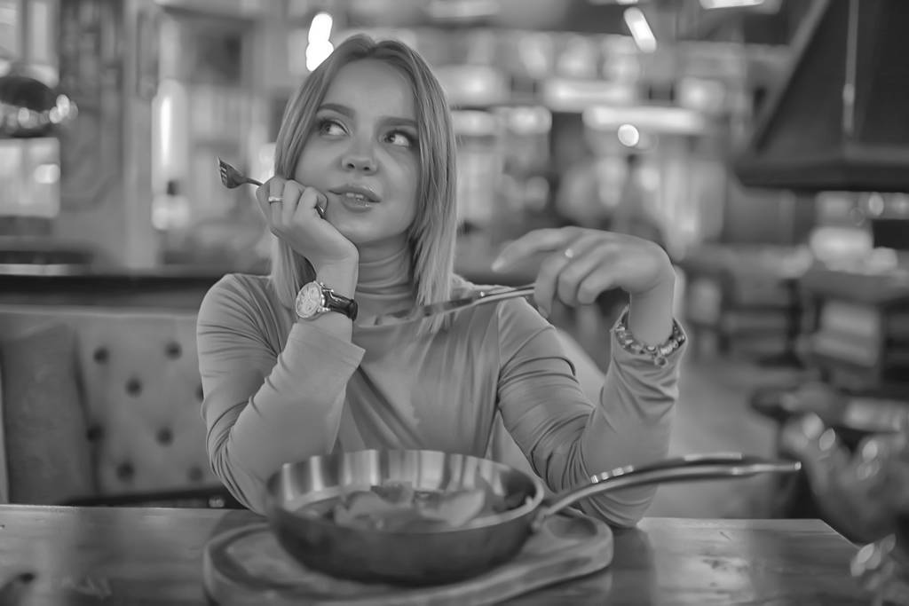 európai étterem ebéd lány, gyönyörű asztal beállítás, fiatal modell pózol evés közben - Fotó, kép