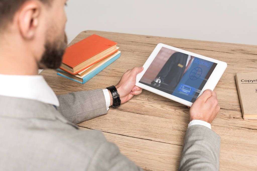 обрізаний вид бізнесмена за допомогою цифрового планшета з додатком бронювання на екрані ізольовано на сірому
 - Фото, зображення
