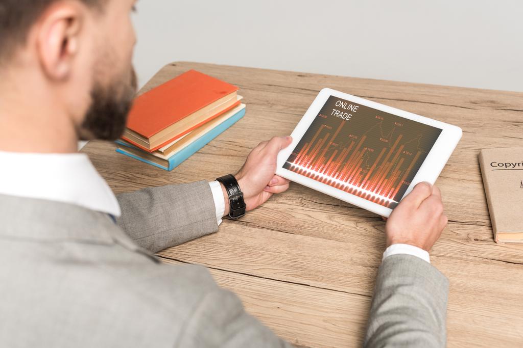 osittainen näkymä liikemies käyttää digitaalista tabletti online-kaupan sovellus ruudulla eristetty harmaa
 - Valokuva, kuva