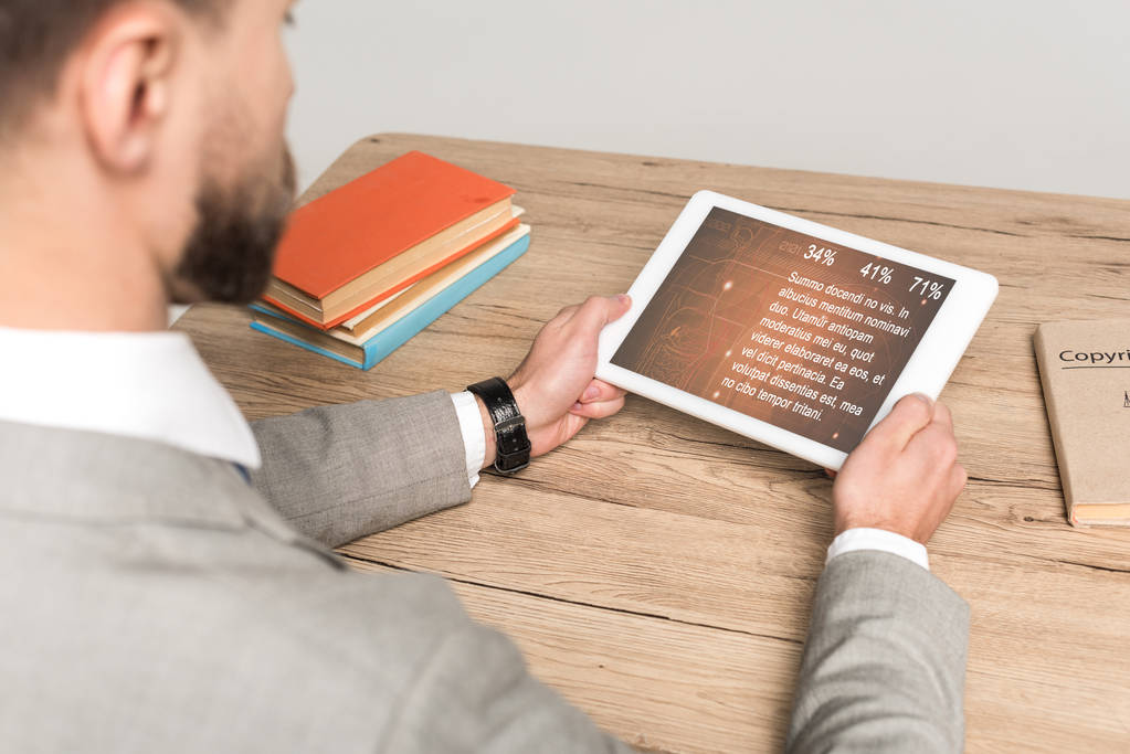 vista ritagliata di uomo d'affari utilizzando tablet digitale con app medica sullo schermo isolato su grigio
 - Foto, immagini