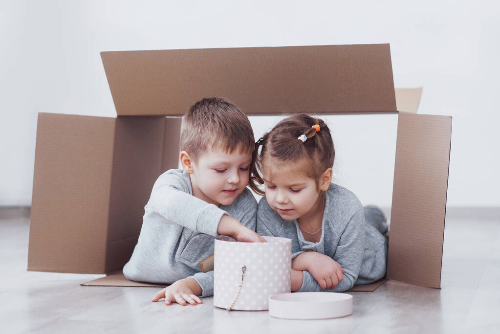 Baby Bruder und Schwester spielen in Kartons im Kinderzimmer. - Foto, Bild