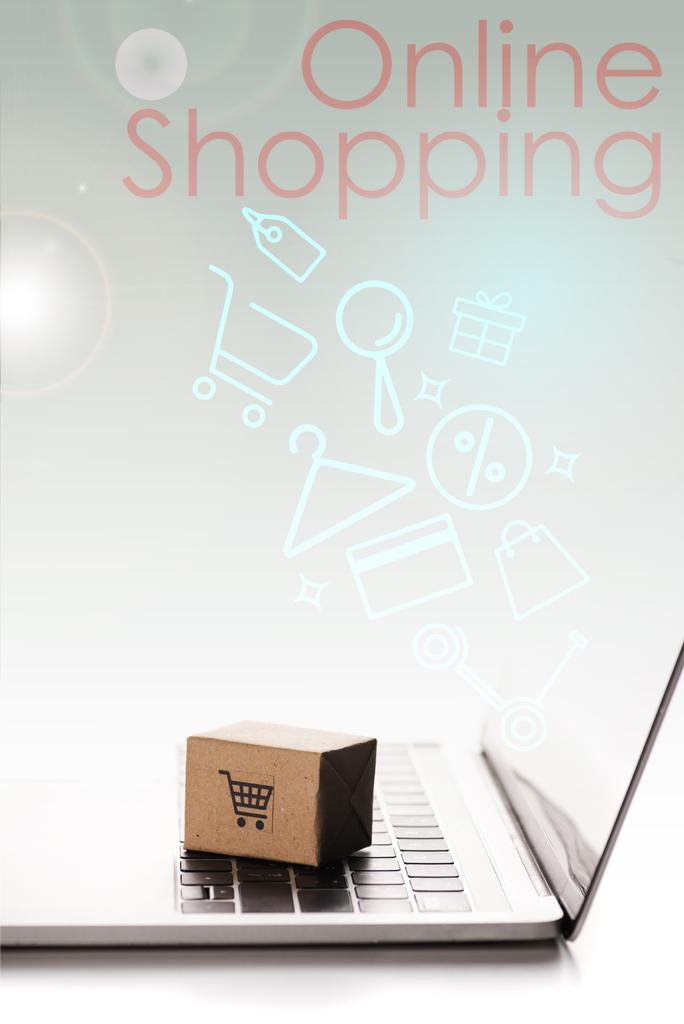 Игрушечная коробка на клавиатуре ноутбука рядом с иллюстрацией и онлайн торговый письма на белом, концепция электронной коммерции
 - Фото, изображение