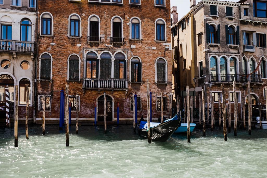 Канал з гондолою та старовинною будівлею у Венеції (Італія).  - Фото, зображення