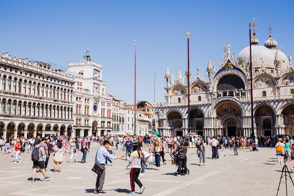 VENECIA, ITALIA - 24 DE SEPTIEMBRE DE 2019: turistas caminando cerca de la Basílica de San Marcos y la torre del reloj en Venecia, Italia
  - Foto, imagen