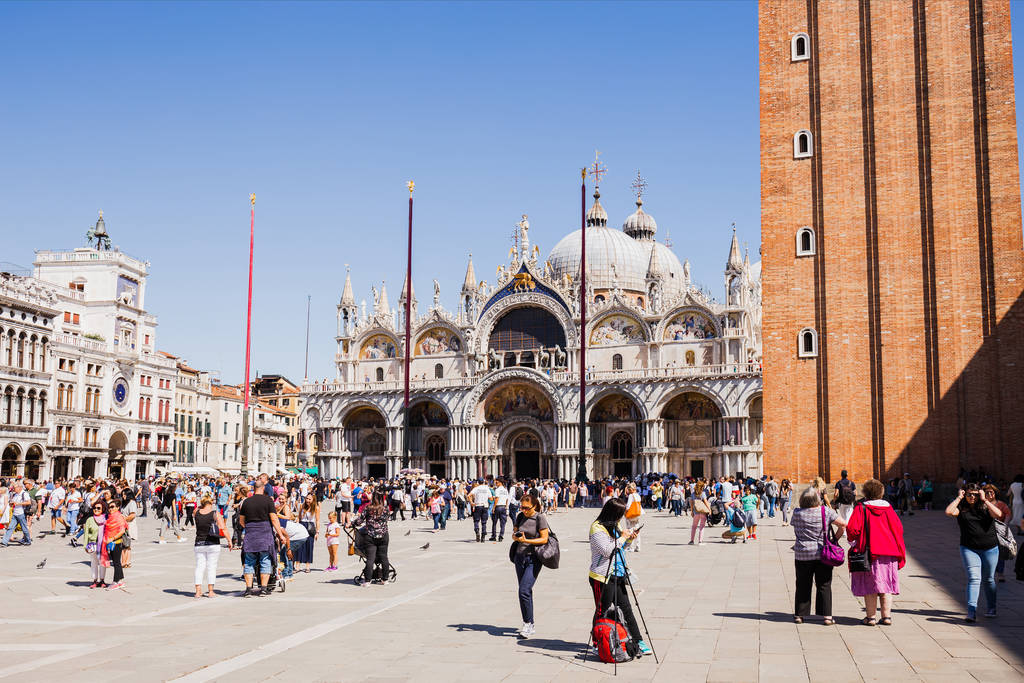 VENICE, ITALY - SEPTEMBER 24, 2019: tourists walking near Basilica of Saint Mark and clock tower in Venice, Italy  - Photo, Image