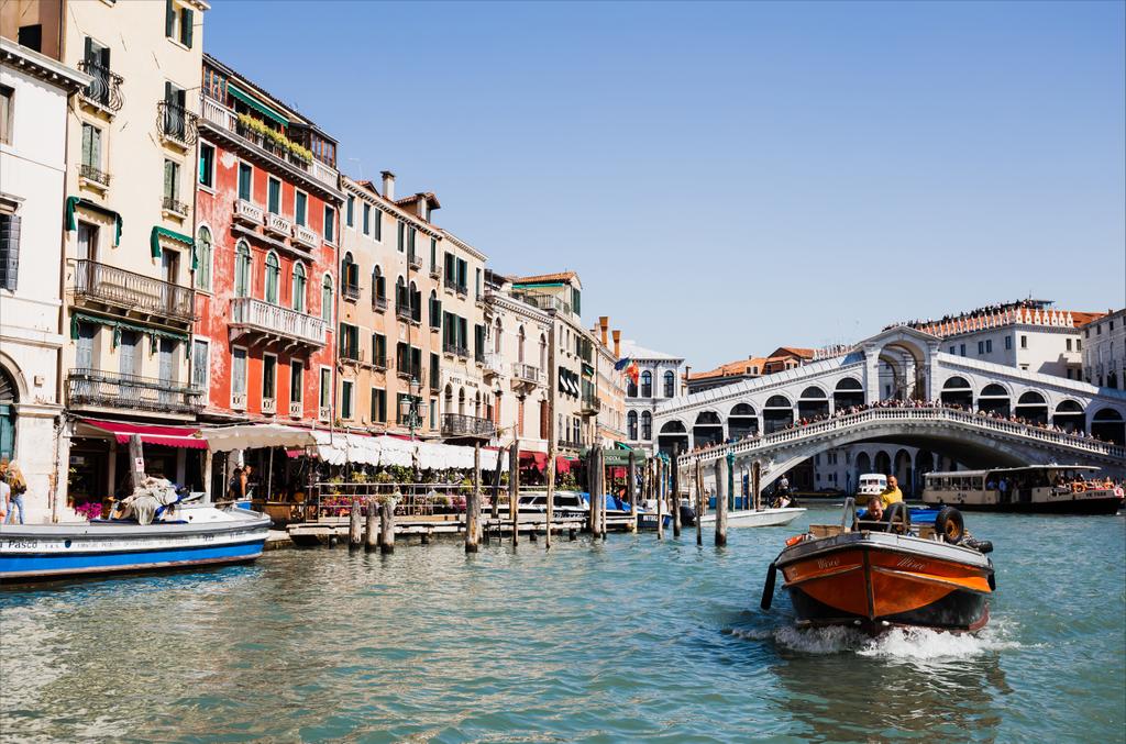 VENICE, ITALY - SEPTEMBER 24, 2019: Rialto Bridge, ancient buildings and motor boat floating on canal in Venice, Italy  - Photo, Image