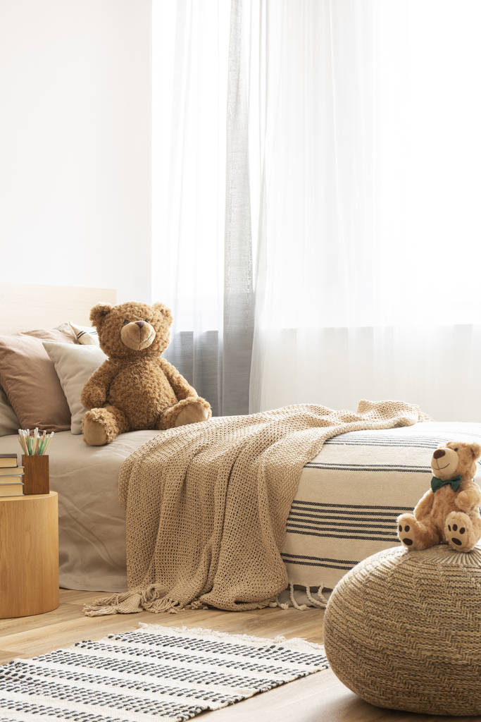 Χαριτωμένο αρκουδάκι σε μονό κρεβάτι στο φωτεινό παιδικό δωμάτιο - Φωτογραφία, εικόνα
