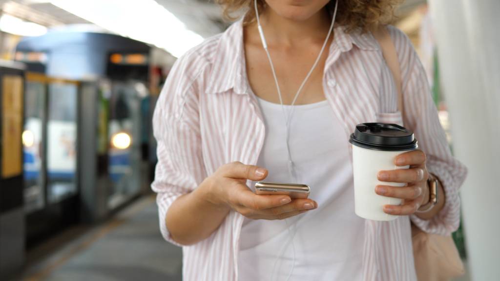 Hipster-Mädchen mit Coffee to go mit Smartphone auf Bahnsteig wartet auf Zug - Foto, Bild