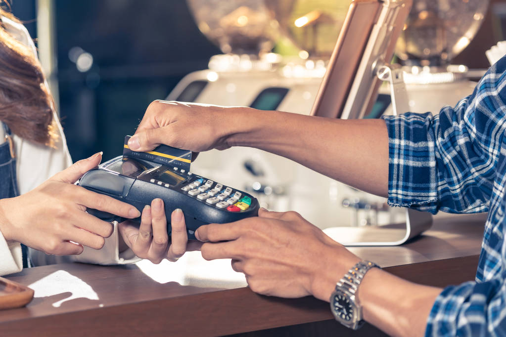 Primer plano de cliente asiático usando su tarjeta de crédito para deslizar con EDC para pagar a un barista por su compra de café en un bar
. - Foto, imagen