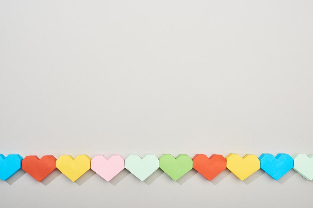 Κάτοψη διακοσμητικών χαρτιών σε σχήμα καρδιάς σε γκρι φόντο με αντιγραφικό χώρο - Φωτογραφία, εικόνα