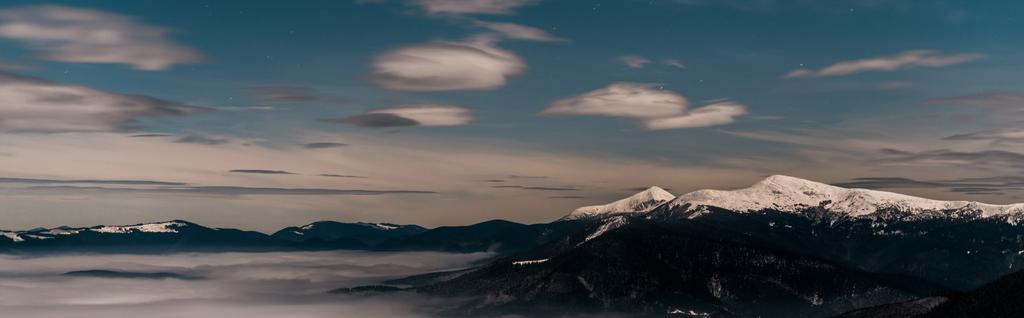 vista panoramica sulle montagne innevate con nuvole bianche e soffice in serata, scatto panoramico
 - Foto, immagini