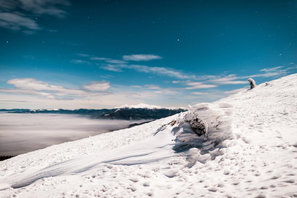 γραφική θέα χιονισμένο βουνό με πεύκο και λευκά χνουδωτά σύννεφα - Φωτογραφία, εικόνα