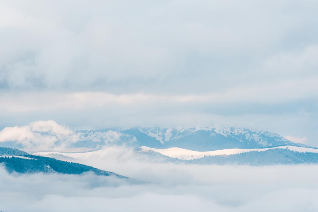 白いふわふわの雲の中の雪の山の景色 - 写真・画像