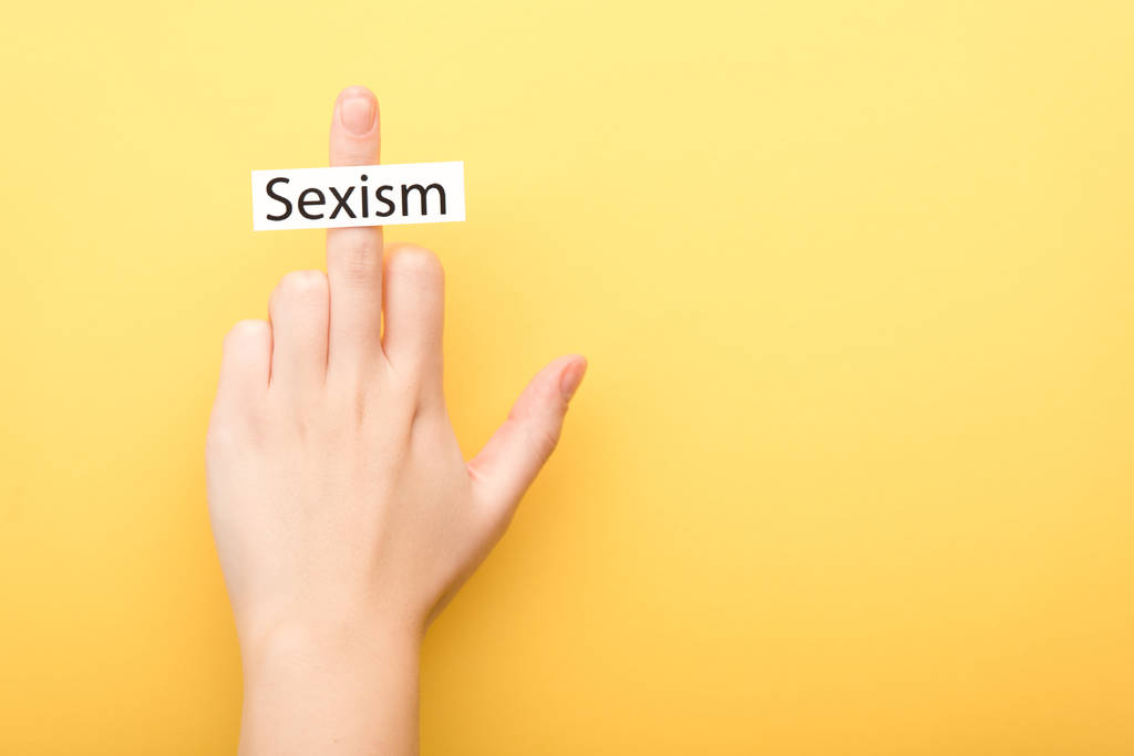 przycięte widok człowiek pokazując środkowy palec z karta seksizm izolowane na żółty - Zdjęcie, obraz