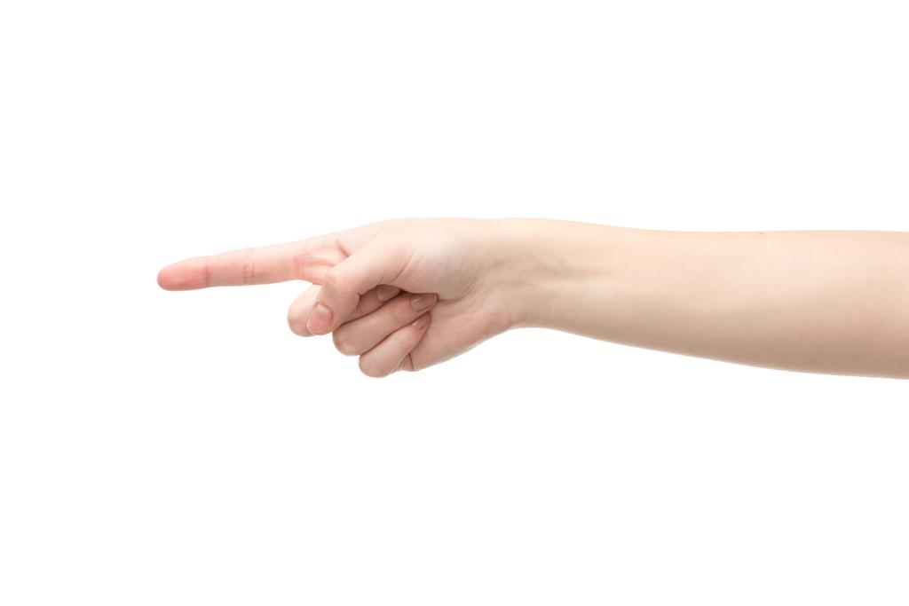 abgeschnittene Ansicht einer Frau, die mit dem Finger auf Weiß zeigt - Foto, Bild