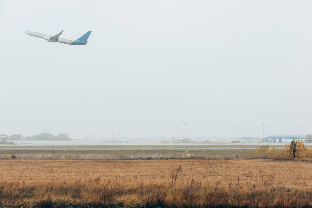 Abflug des Flugzeugs auf Flugplatz bei bewölktem Himmel - Foto, Bild