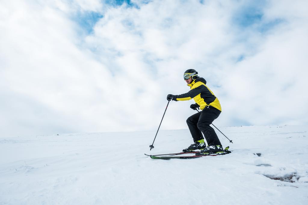 Kasklı ve gözlüklü sporcu yamaçta kayak yapıyor.   - Fotoğraf, Görsel