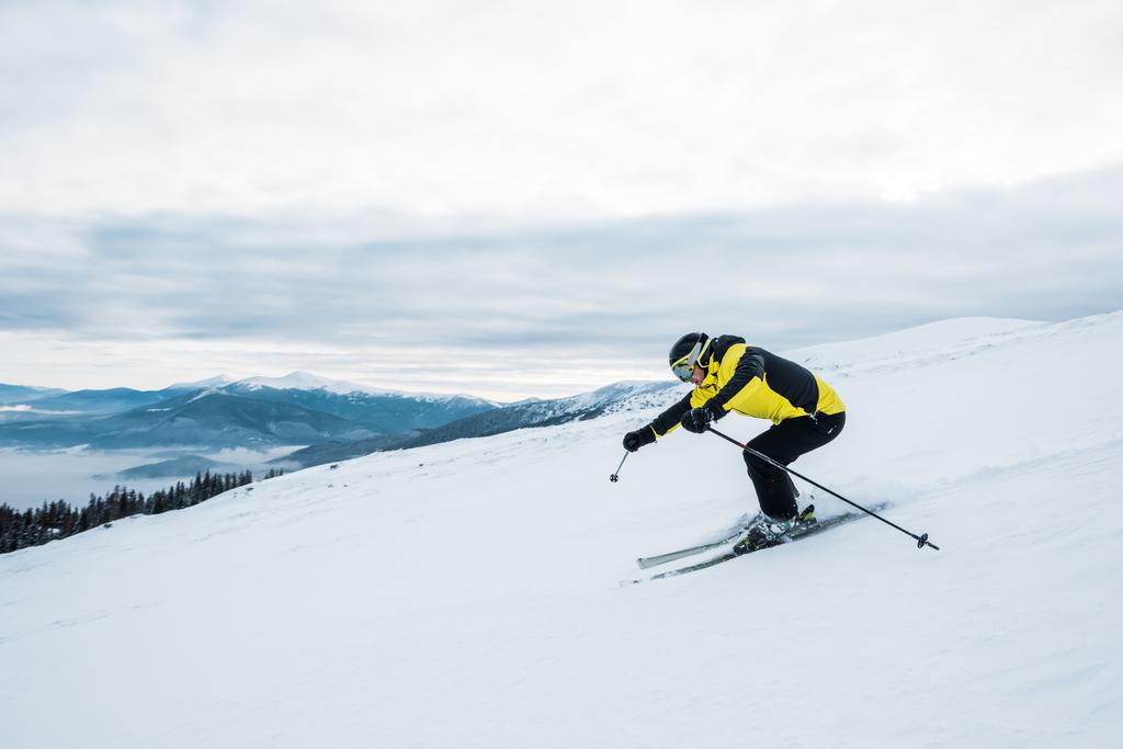 atletický muž v helmě a brýlích lyžování na sjezdovce   - Fotografie, Obrázek