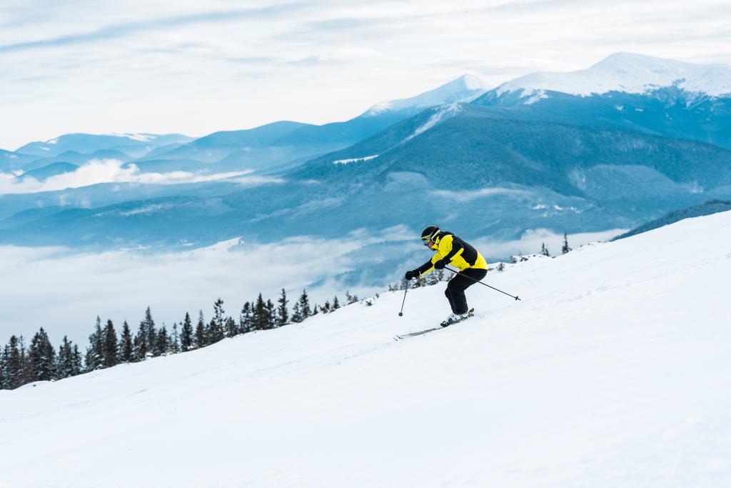 Sporcu sopaları tutuyor ve dağlarda karla yamaçta kayak yapıyor.  - Fotoğraf, Görsel