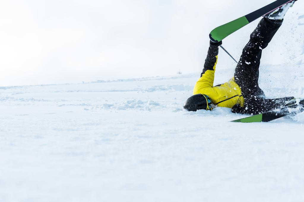 sportovec v helmě padající při lyžování na sjezdovce  - Fotografie, Obrázek
