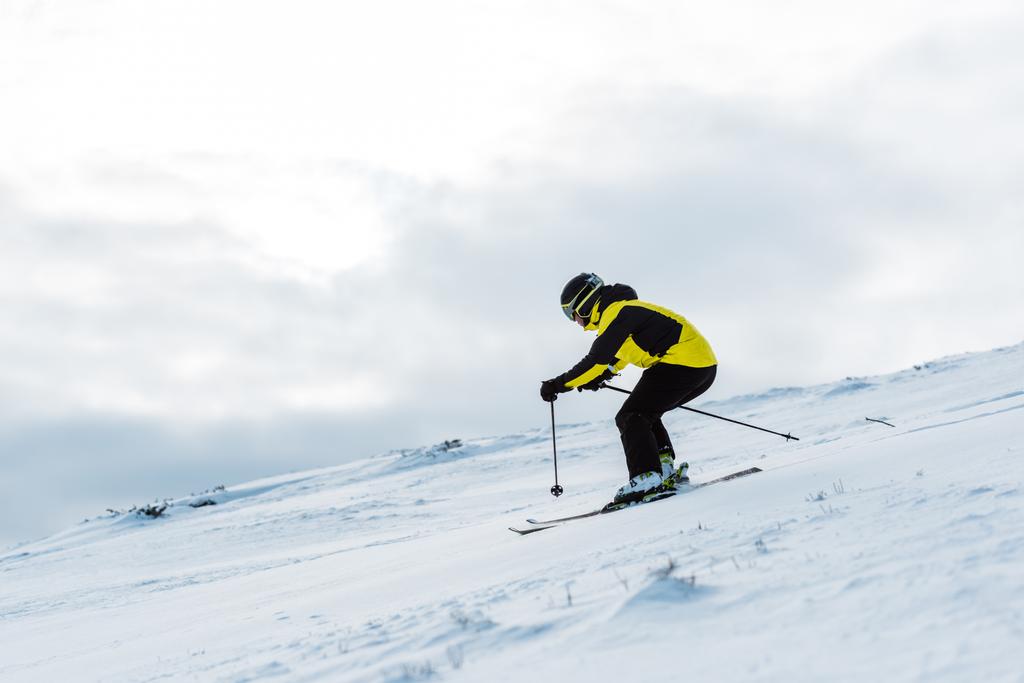 ヘルメットとゴーグルのスポーツマンは冬の斜面でスキーをします  - 写真・画像
