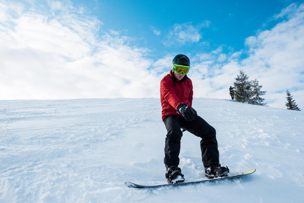 Atletik snowboardcu kışın bulutlu mavi gökyüzüne doğru gidiyor.  - Fotoğraf, Görsel