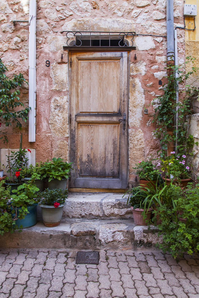 Villefranche-sur-Mer, Franciaország, 2019. október 10. Tipikus provence-i építészet. Az épület homlokzatának töredéke a régi városban. A bejárati ajtó hagyományos kialakítása - Fotó, kép