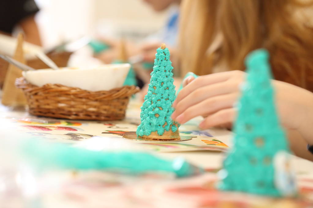 Τα χέρια των παιδιών φτιάχνουν χριστουγεννιάτικο δέντρο από μπισκότα. Βρώσιμο δέντρο - Φωτογραφία, εικόνα