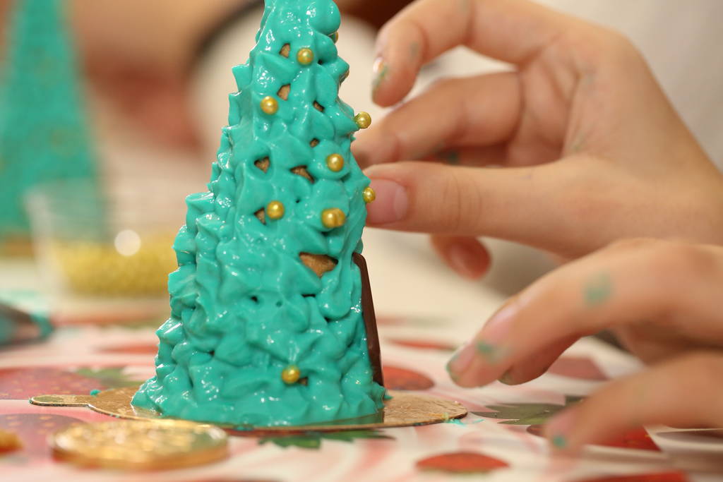 Τα χέρια των παιδιών στολίζουν ένα χριστουγεννιάτικο δέντρο από μπισκότα - Φωτογραφία, εικόνα