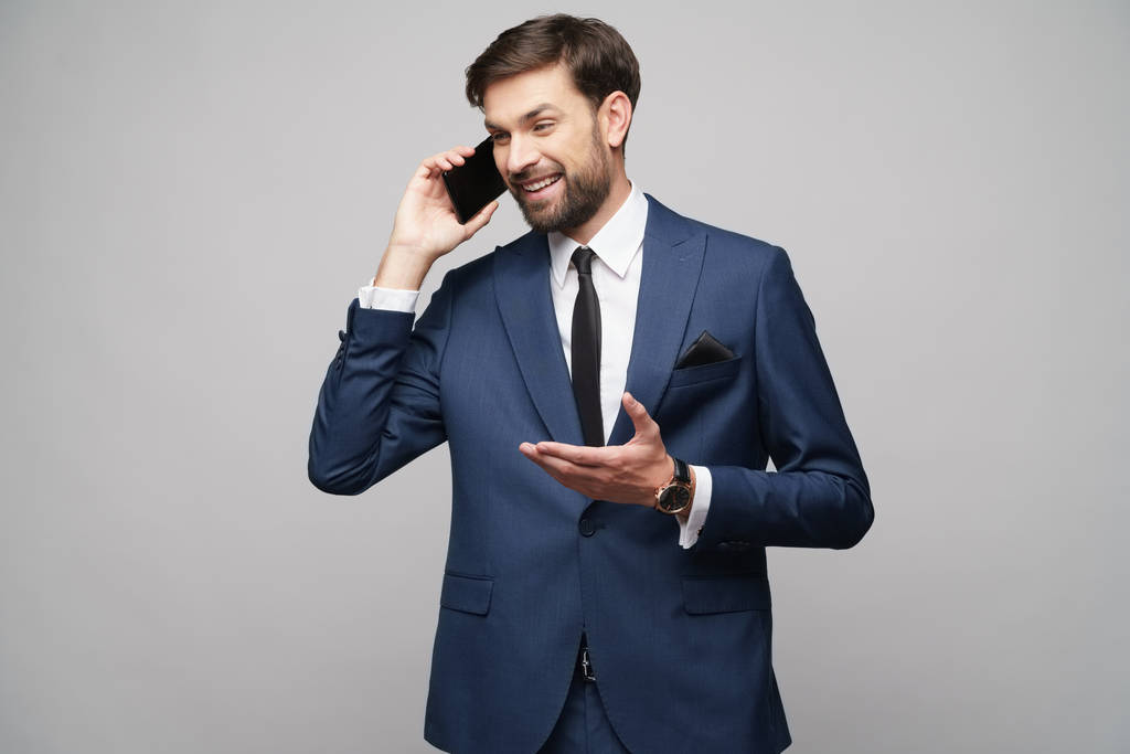 бизнесмен разговаривает по телефону изолированы на сером фоне
 - Фото, изображение