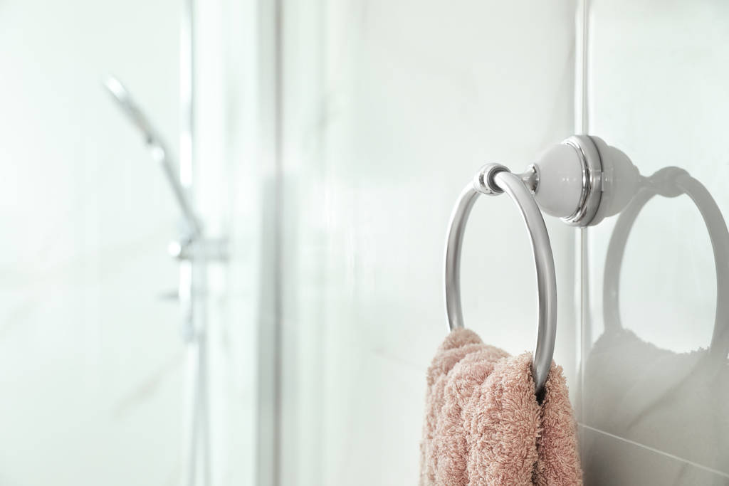 Držák s čistým ručníkem na světlé zdi v koupelně - Fotografie, Obrázek